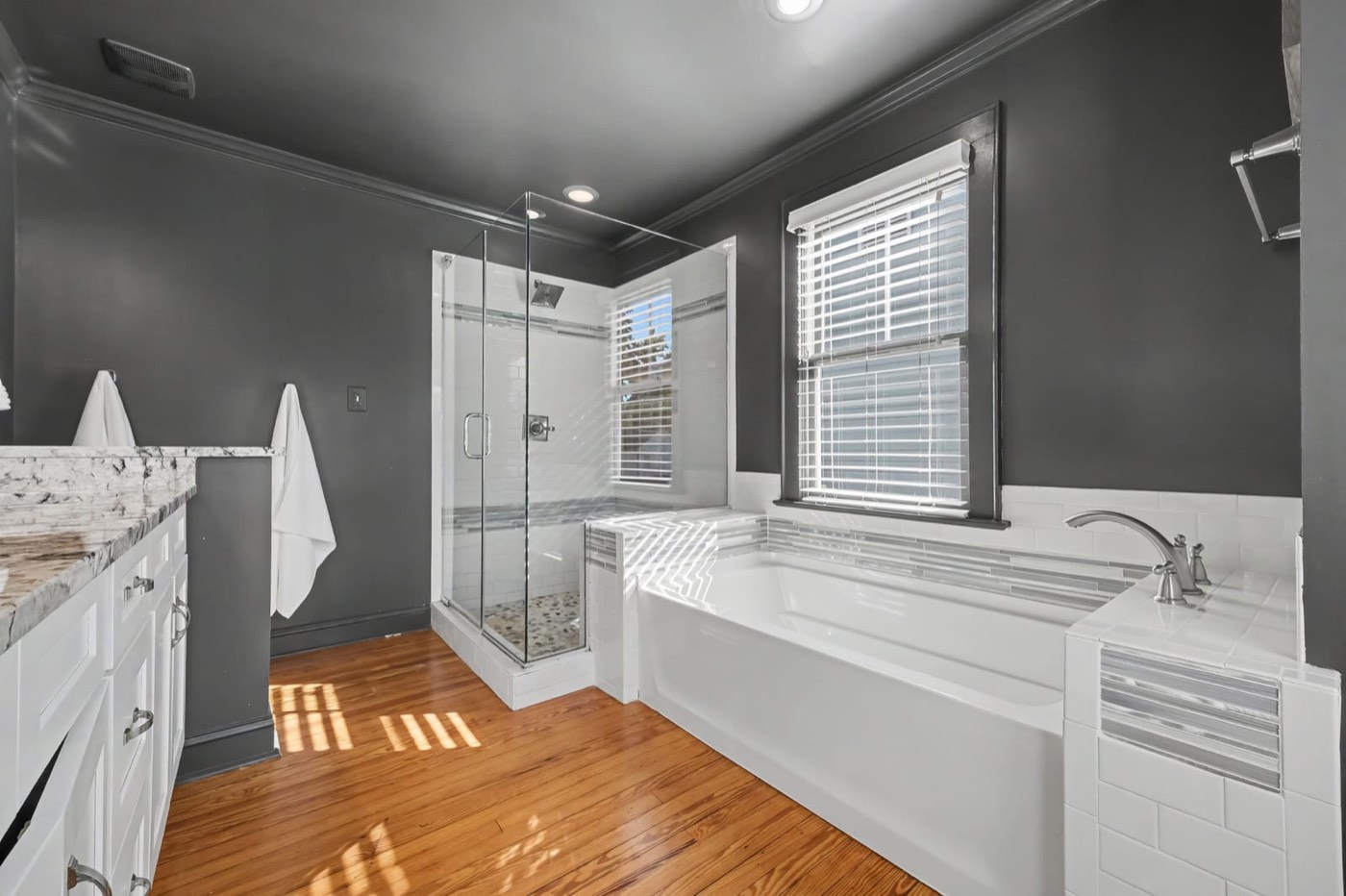 Renovated primary bath with soaker tub and glass walk-in shower