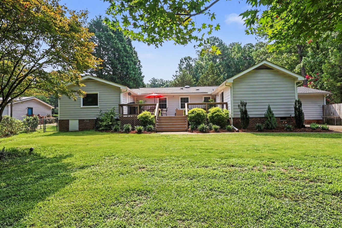 The house and front lawn under tall pines