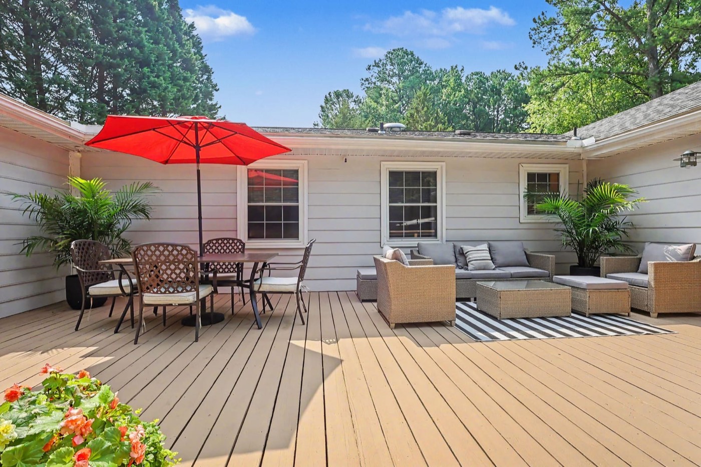 Large back deck with outdoor seating and a red umbrella